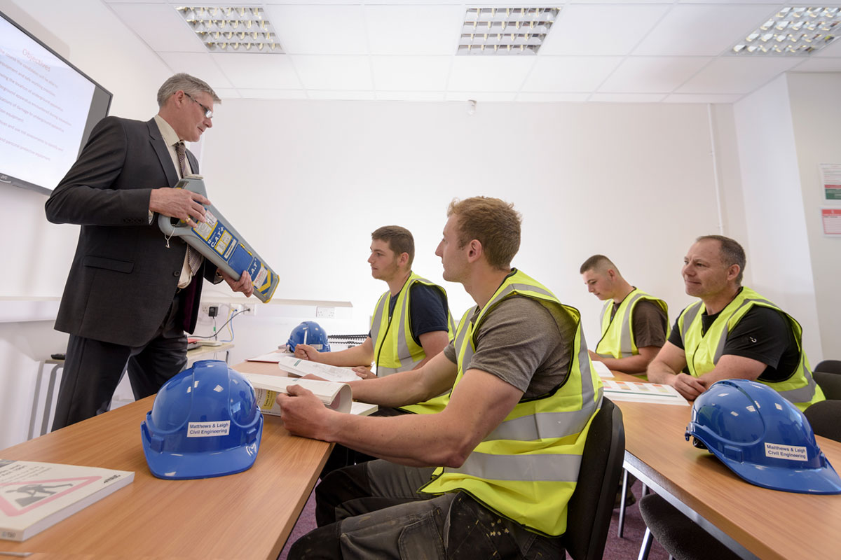 Onsite English language training session for construction workers wearing safety vests