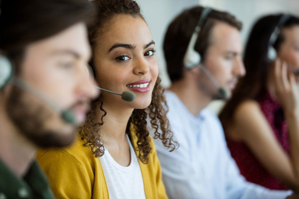 Customer Service Employees are on the phone with clients, equipped with headsets.
